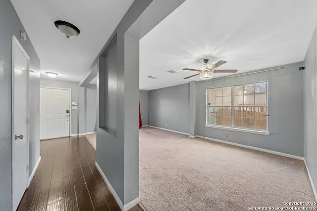 a view of hallway with windows and chandelier fan