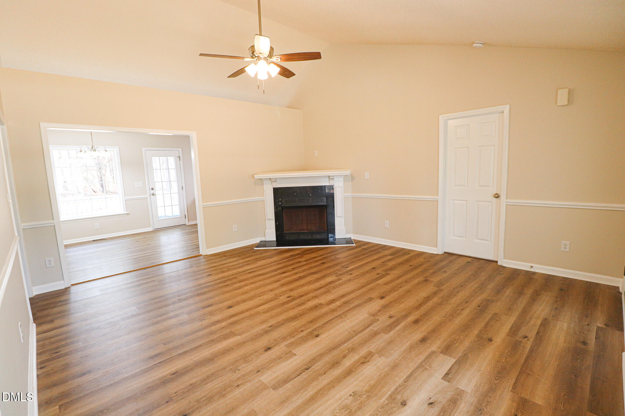55 Edward Court Willow Spring, NC 27592 - Photo 15 of 25 an empty room with wooden floor chandelier fan and windows