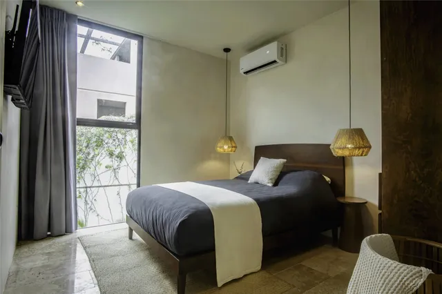 a bedroom with a bed and a potted plant