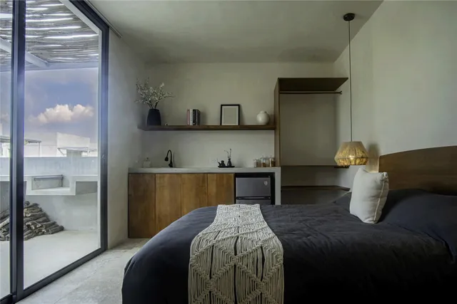 a bedroom with a bed and a potted plant on the dresser