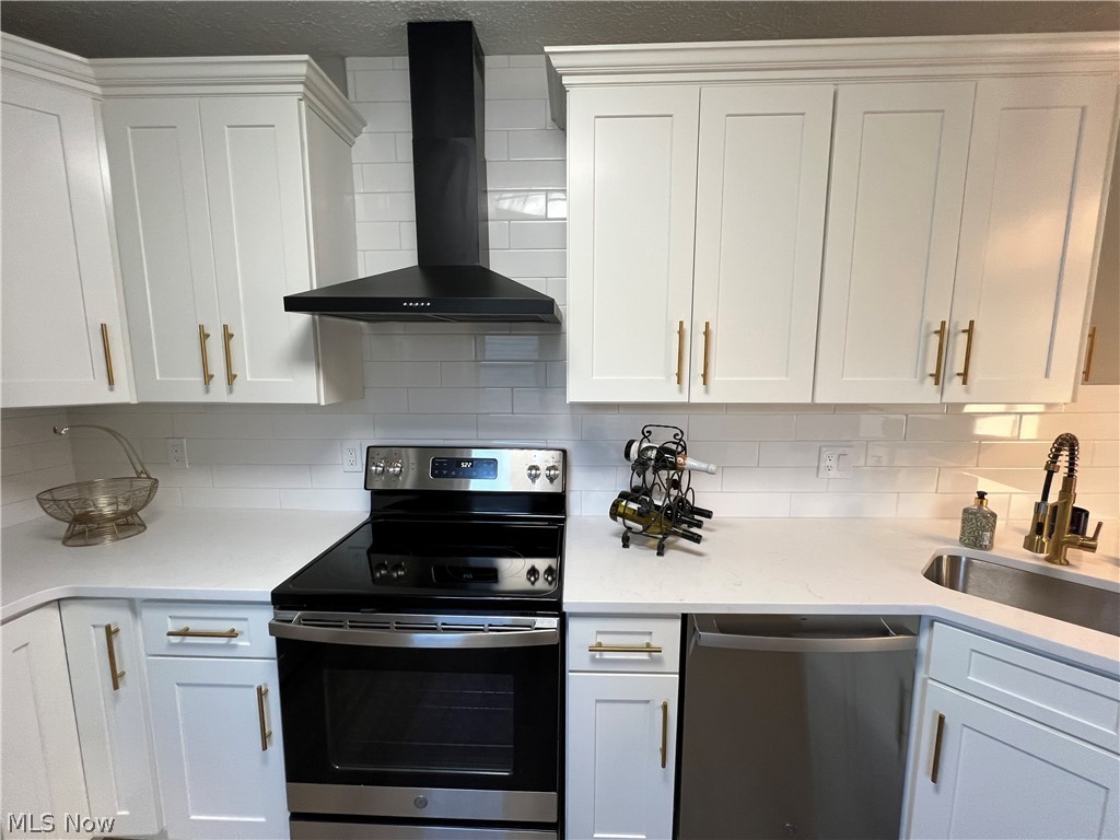 4523 Maplecrest Avenue Parma, OH 44134 - Photo 9 of 31 Kitchen featuring wall chimney exhaust hood, backsplash, white cabinetry, and appliances with stainless steel finishes
