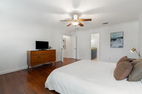 a bedroom with a bed and wooden floor
