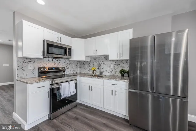 a kitchen with stainless steel appliances granite countertop a refrigerator stove a sink and a microwave