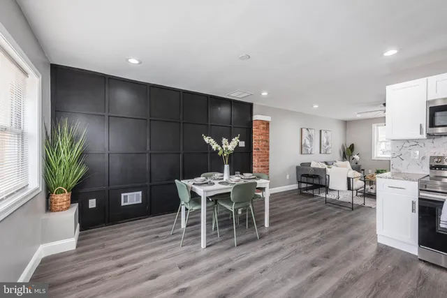 a dining room with furniture potted plants and wooden floor