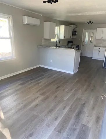 a kitchen with granite countertop a sink stainless steel appliances and white cabinets