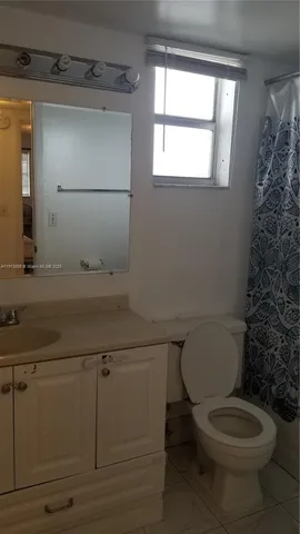 a bathroom with a toilet a sink and a window