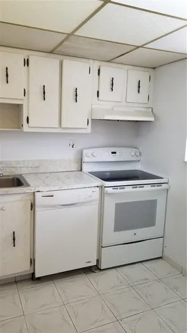 a kitchen with white cabinets and white appliances