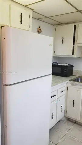a white refrigerator freezer sitting in a kitchen