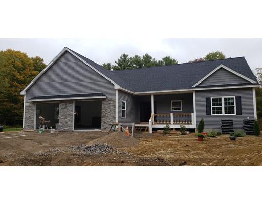 a front view of a house with a garden and trees