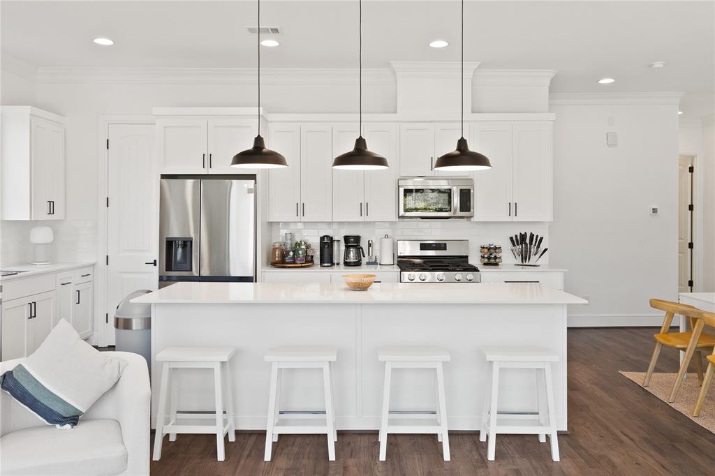 5014 Mission Avenue, Unit A Dallas, TX 75206 - Photo 4 of 26 a kitchen with stainless steel appliances granite countertop a sink a stove a refrigerator and white cabinets with wooden floor