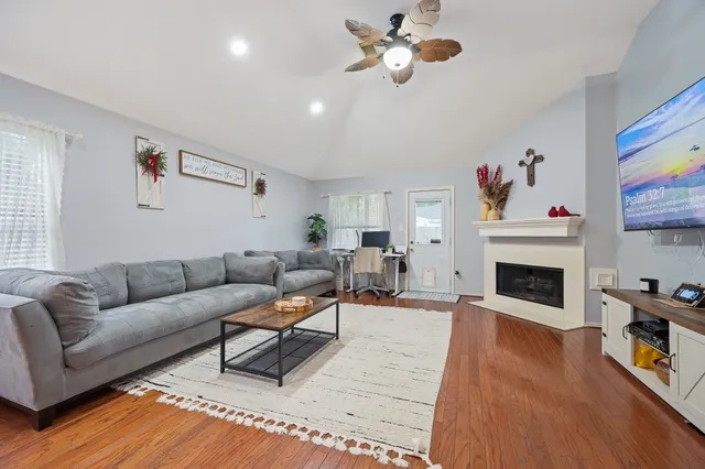 a living room with furniture a fireplace and a flat screen tv