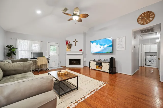 a living room with furniture a fireplace and a flat screen tv