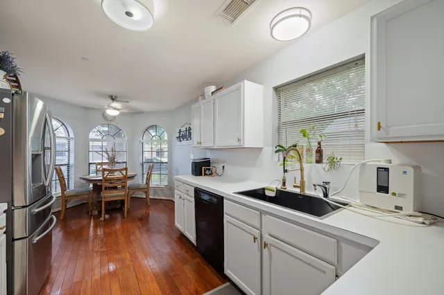 a kitchen that has a lot of cabinets a sink and appliances in it