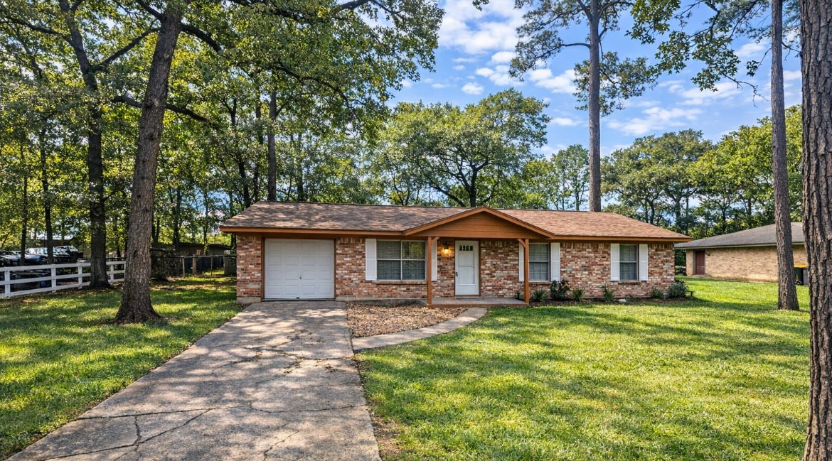 3699 Piney Point Road Conroe, TX 77301 - Photo 1 of 16 a front view of a house with garden