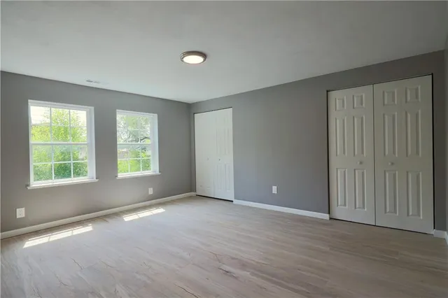 a view of hallway with window and wooden floor