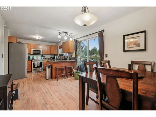 a open kitchen with stainless steel appliances refrigerator dining table and chairs