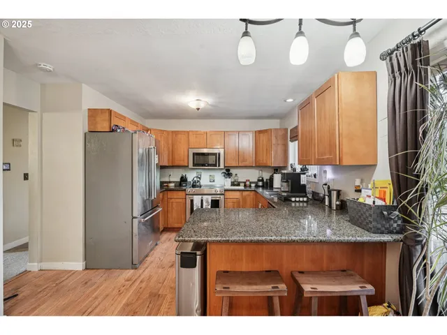 a kitchen with stainless steel appliances granite countertop a refrigerator a sink a stove and island