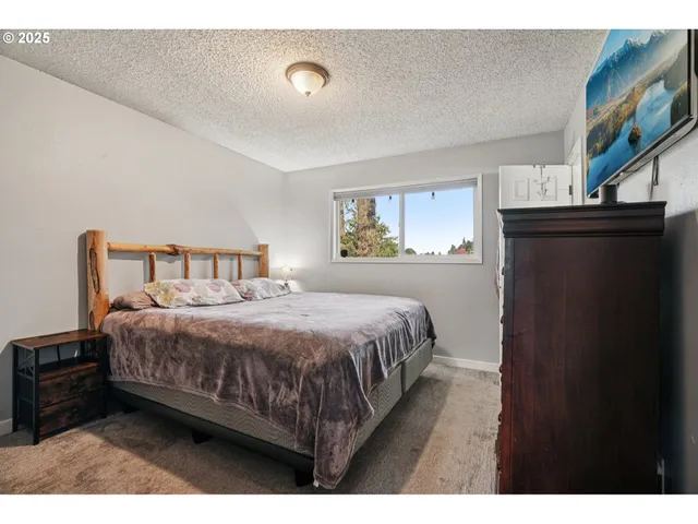 a bedroom with a bed a mirror and a chair