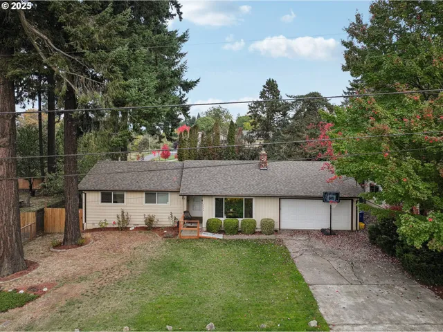 a backyard of a house with table and chairs and wooden fence