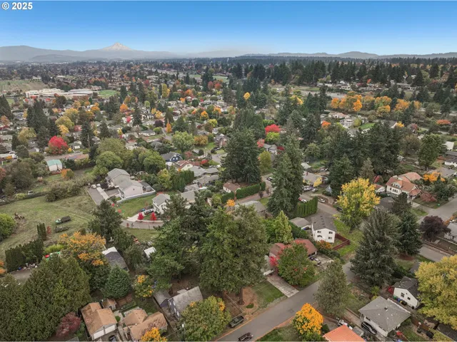 a view of a big yard with table and chairs a fire pit and a large tree