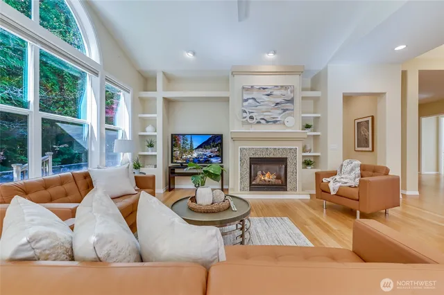 a living room with furniture a fireplace and a large window