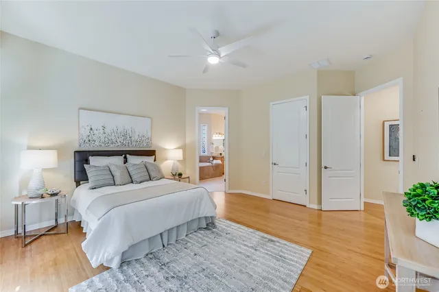 a spacious bedroom with a bed and a painting on the wall