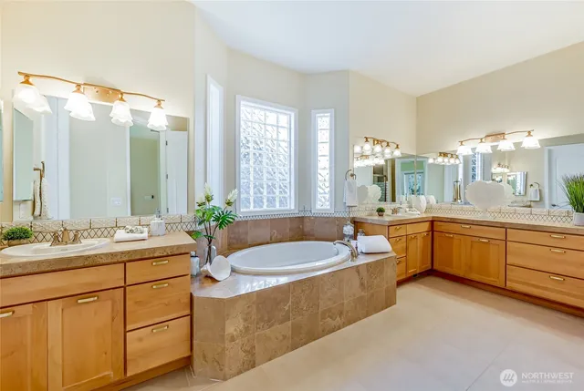 a bathroom with a granite countertop tub sink and mirror