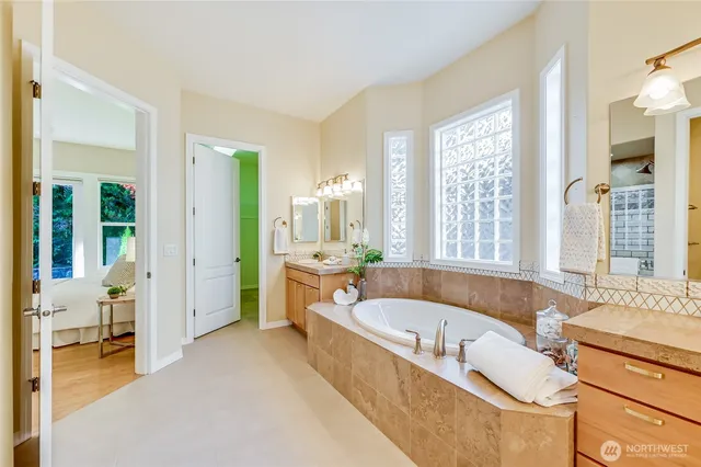 a large tub sitting in a spacious bedroom next to a window