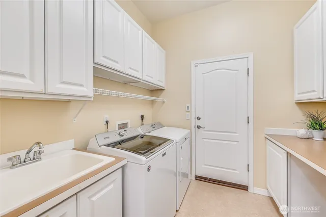 a utility room with sink dryer and washer