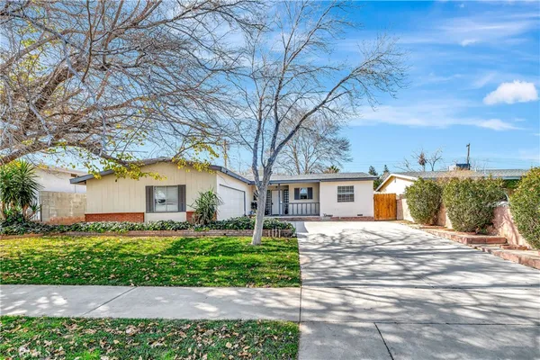 a front view of a house with a yard and potted plants