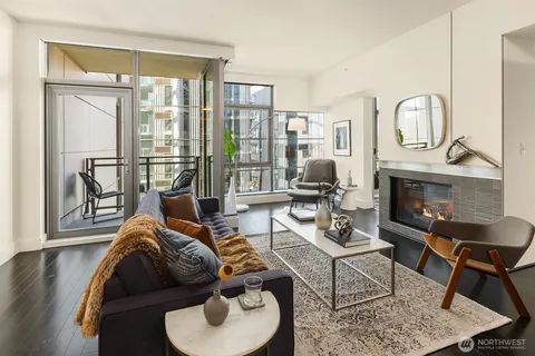 a living room with furniture fireplace and a large window