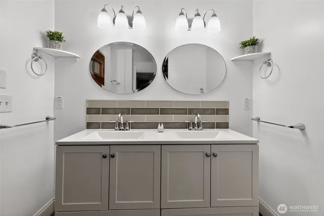 a bathroom with a double vanity sink and a mirror