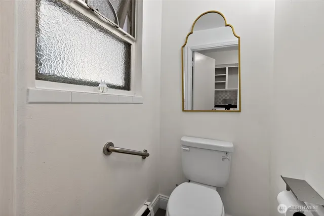 a bathroom with a toilet a sink and mirror