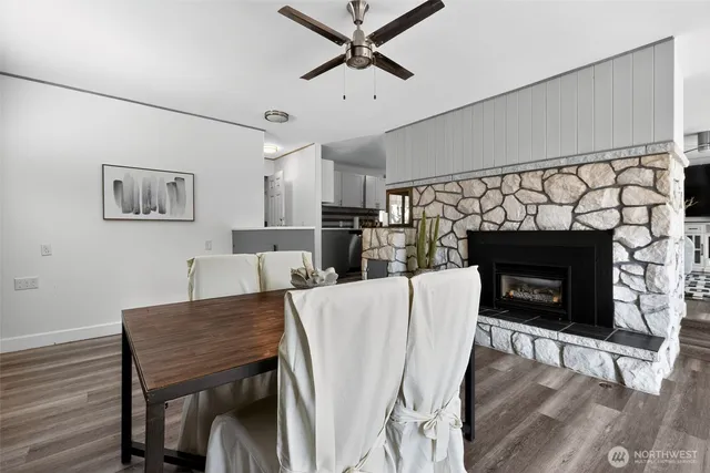 a living room with furniture a fireplace and a ceiling fan