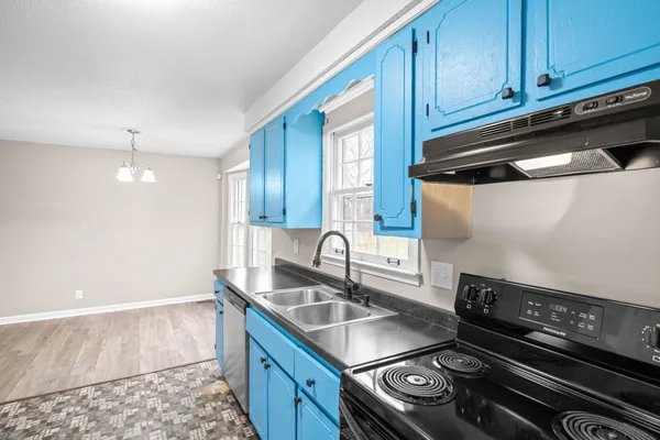 a kitchen with granite countertop a sink stove and cabinets