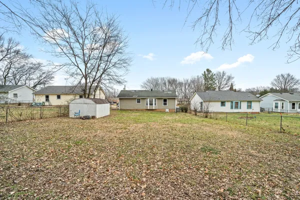 a front view of a house with a garden and trees