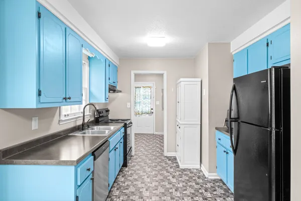 a kitchen with a sink a refrigerator and cabinets