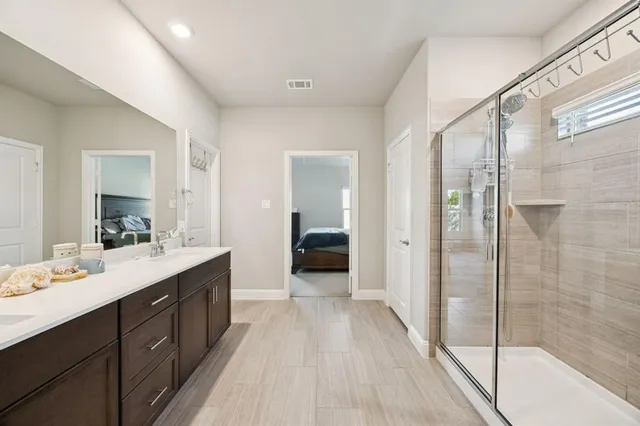 a en suite bathroom with a double vanity sink and a mirror
