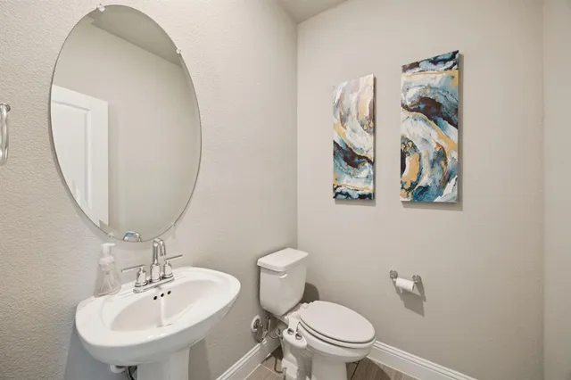 a bathroom with a toilet a sink and mirror