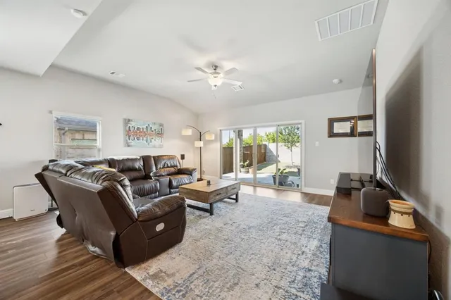 a living room with furniture a large window and flat screen tv