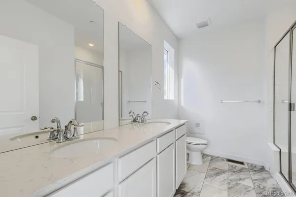 a bathroom with a sink double vanity and a toilet