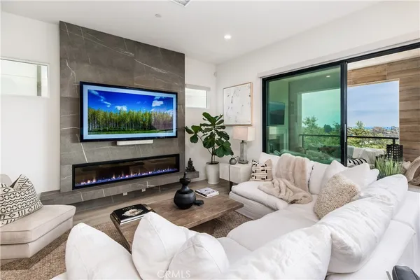 a living room with furniture a flat screen tv and a floor to ceiling window