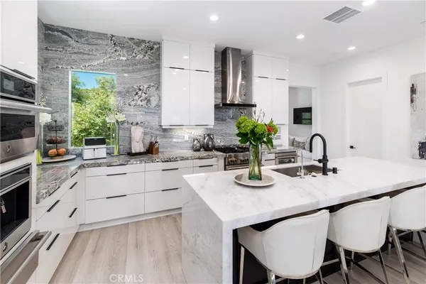 a kitchen with white cabinets and appliances
