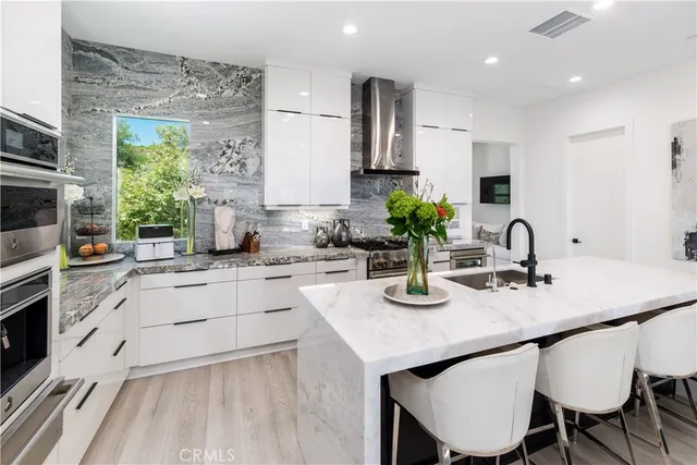 a kitchen with white cabinets and appliances