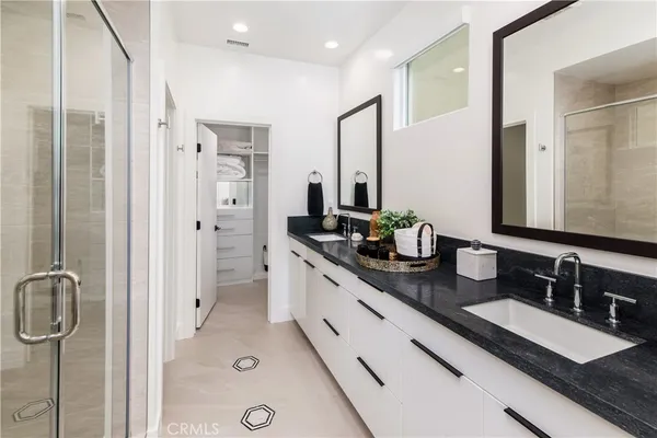 a bathroom with a double vanity sink a mirror and shower