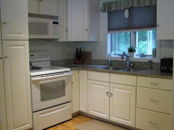 64 Brookside Avenue Webster, MA 01570 - Photo 5 of 30 a kitchen with white cabinets and white appliances