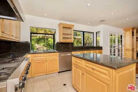 a kitchen with stainless steel appliances granite countertop a stove a sink and a refrigerator