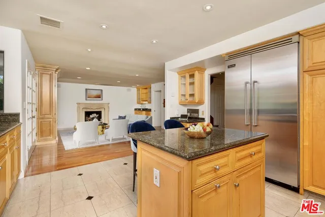 a kitchen with granite countertop a sink and a refrigerator