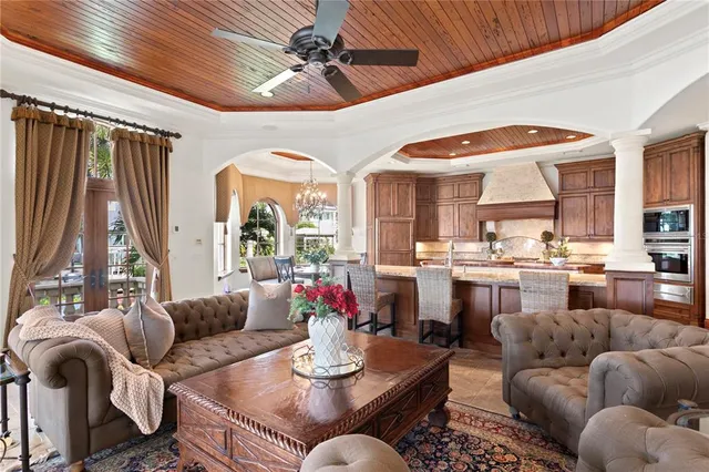 a living room with furniture kitchen view and a large window