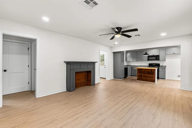 a view of a kitchen with a ceiling fan wooden floor and a kitchen